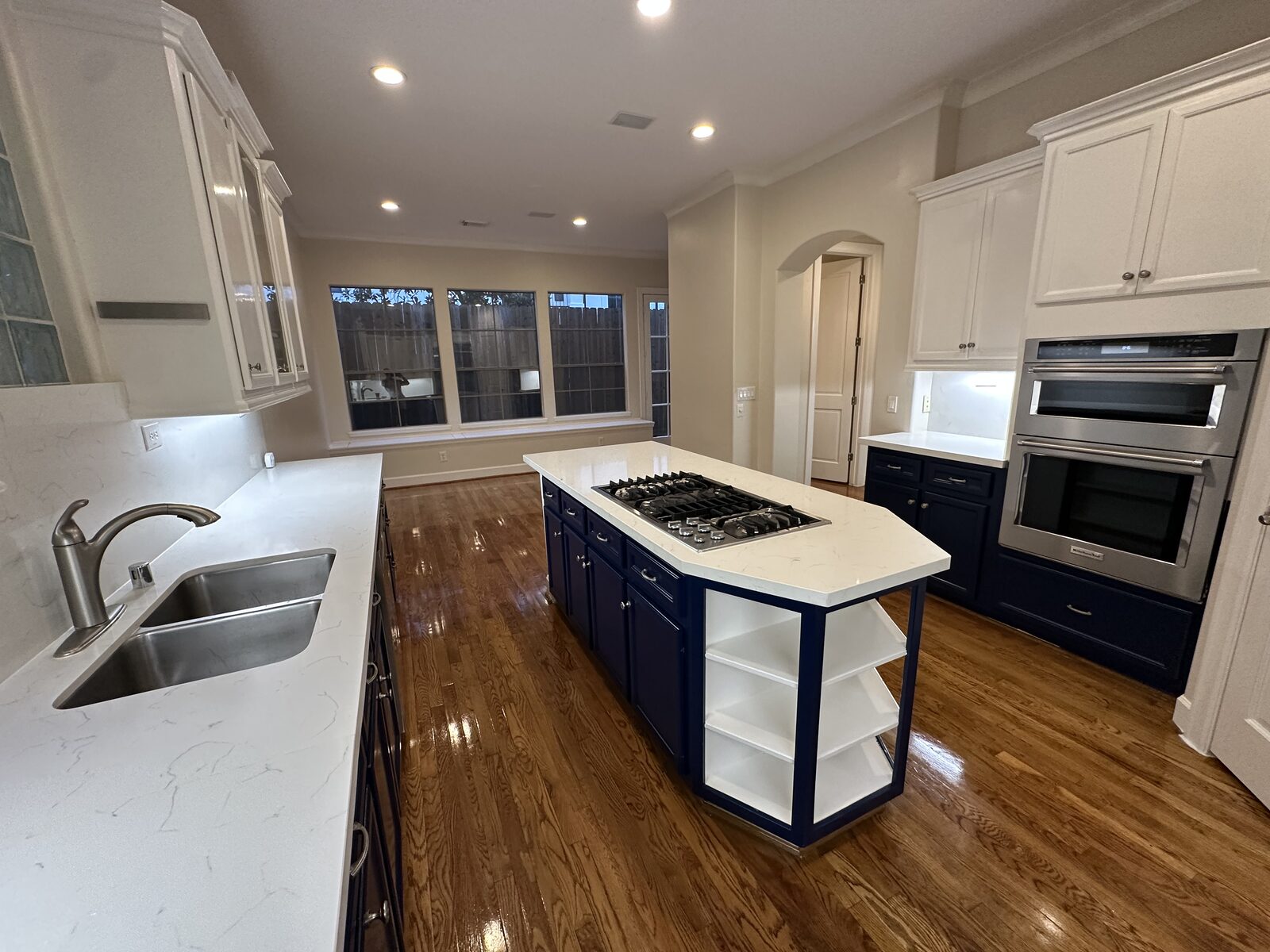 Remodeled kitchen with dark blue island cabinetry